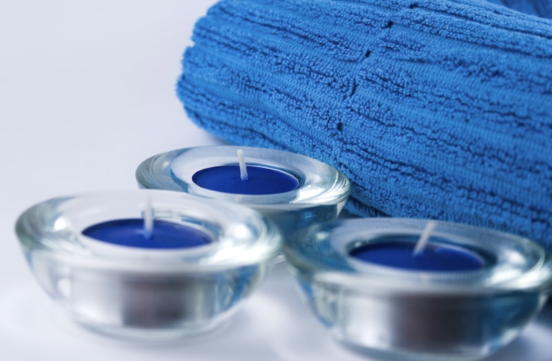 A towel and candles on a white surface