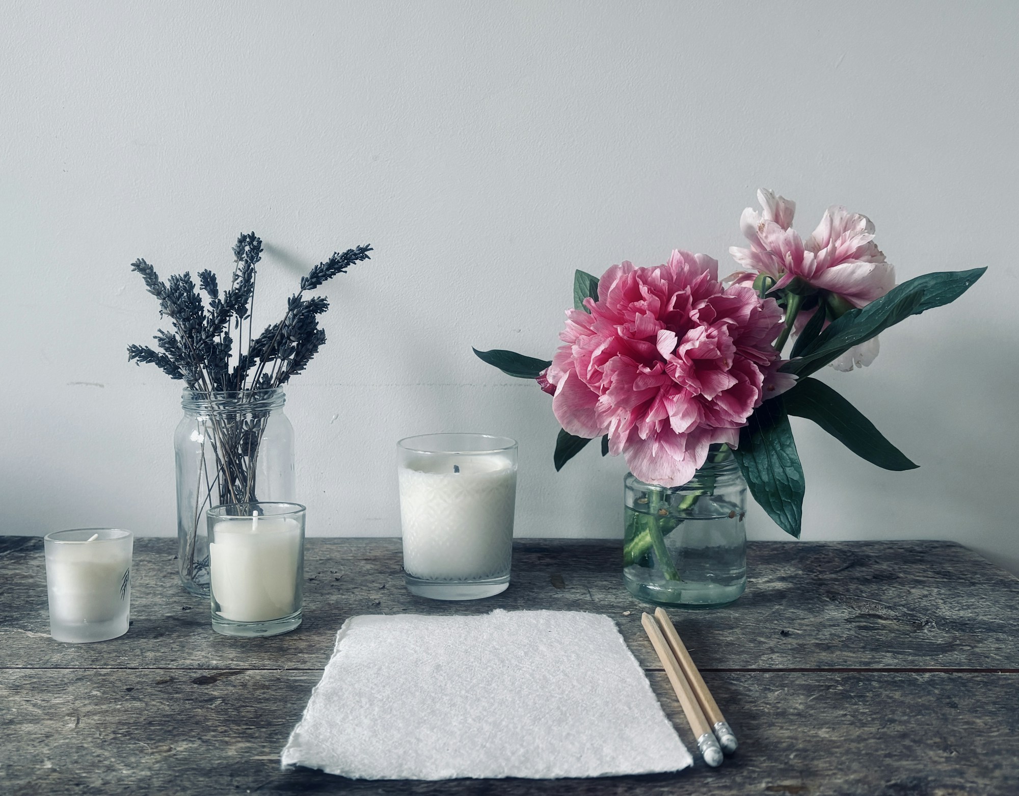 Flowers and candles on a wooden table, botanical styling