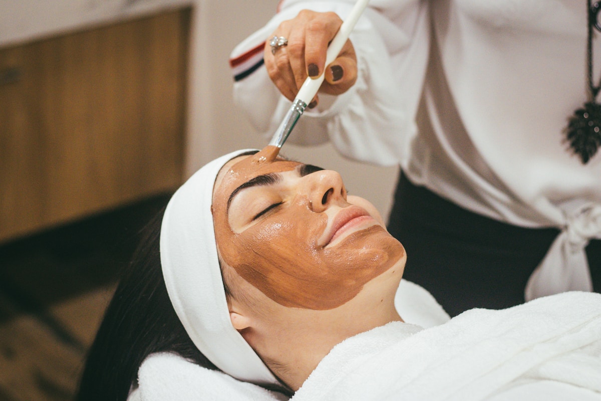 Woman receiving facial mask treatment at spa