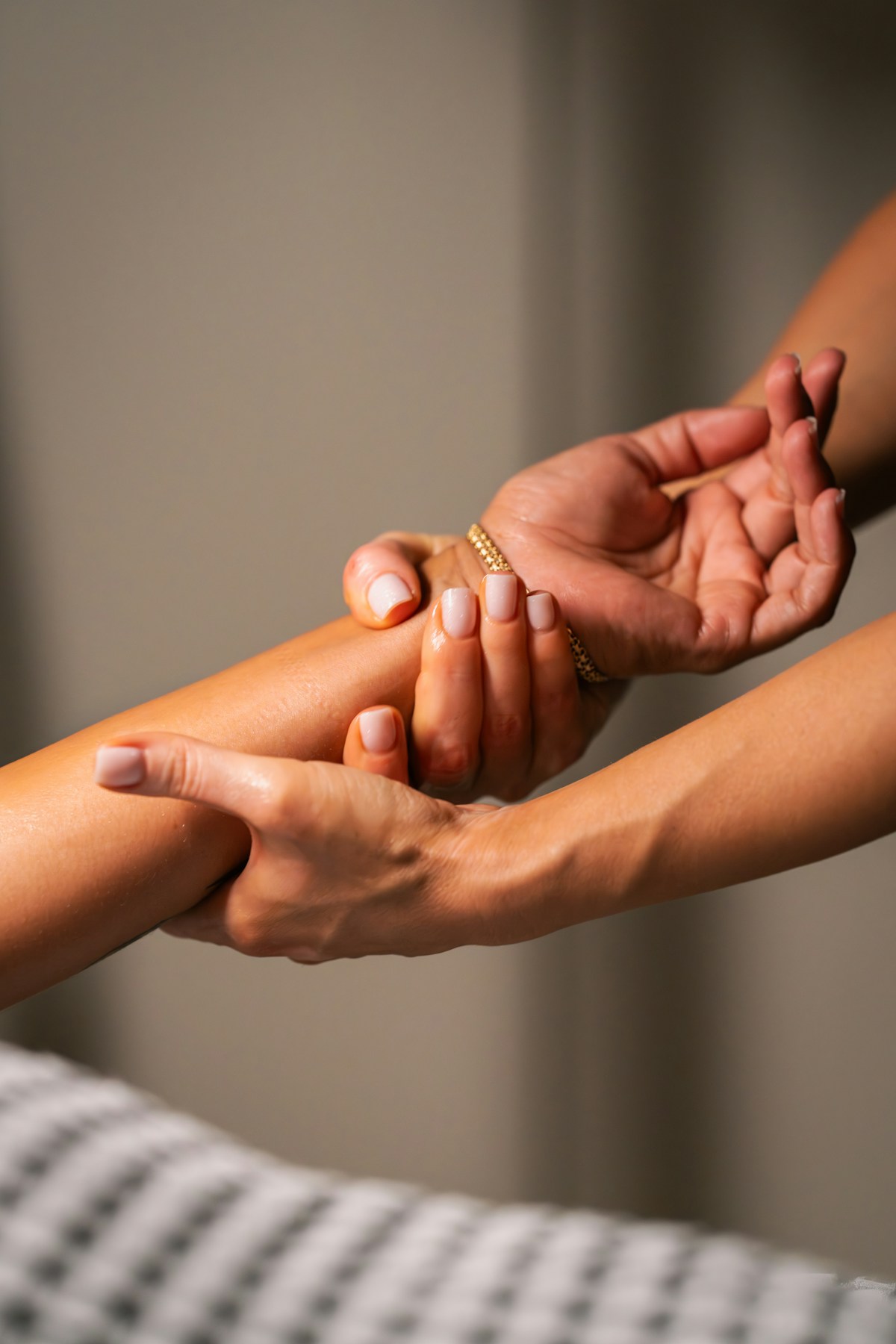 Hands massaging a person's forearm with gentle pressure
